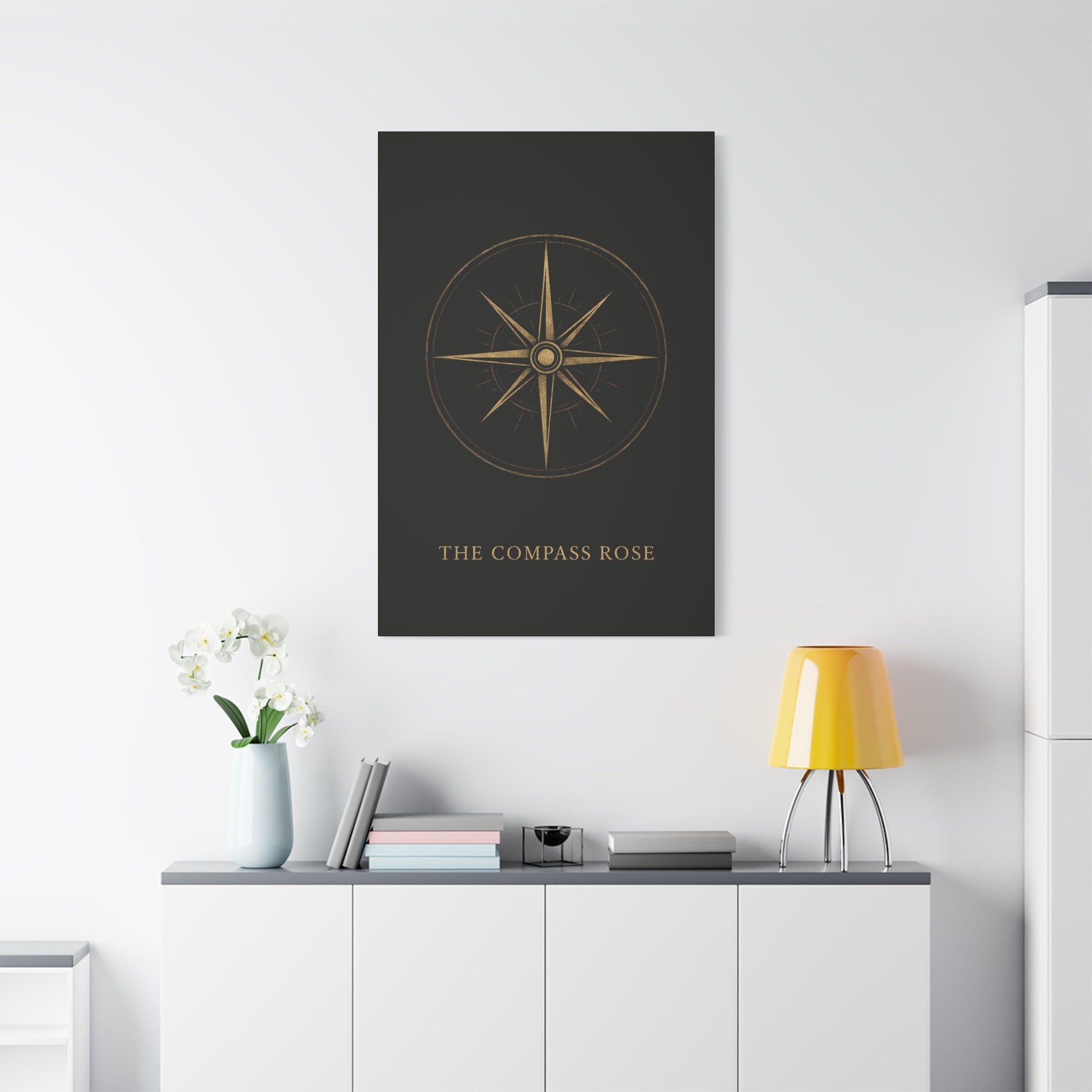 Poster of a compass rose on a wall above a desk with a lamp and books.